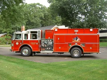 Driver-side full profile showing pumper body, pump panel area, and wheel layout