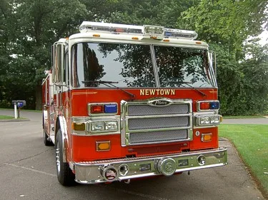 Head-on front view showing grille, bumper lights, and warning bar