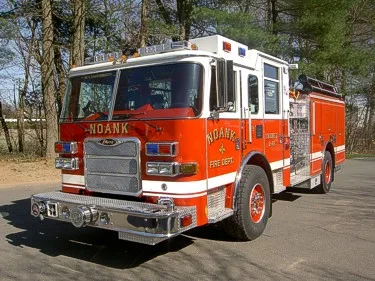 Front-left exterior view showing grille, bumper, and side pump panel area