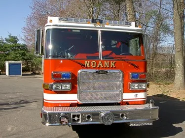 Head-on front view showing grille, bumper-mounted siren, and warning lights