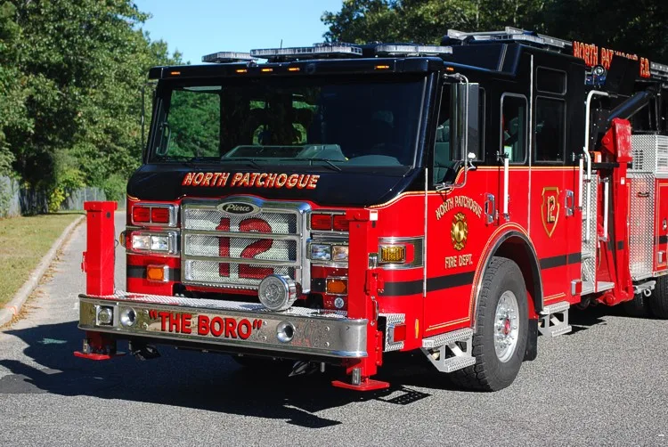Front-left close view showing the grille, front outrigger post, cab door area, and front wheel.
