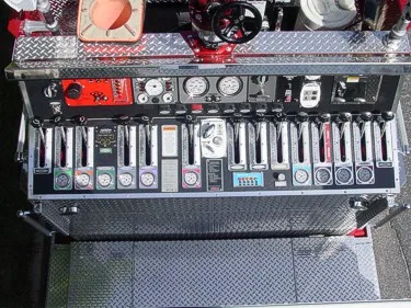 Pump panel close-up showing gauges, levers, valve handles, and intake controls.