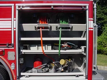 Open side compartment showing long tools, hose rolls, and shelf storage