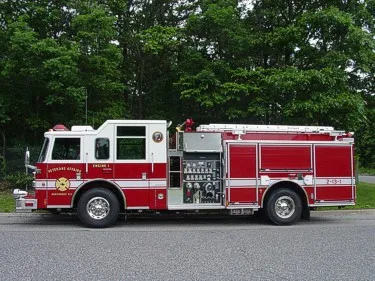 Full right-side profile showing pump controls, roll-up compartment doors, and wheel/tire areas.