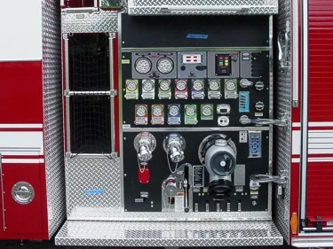 Close-up of the midship pump panel with gauges, intake controls, valves, and switch labels.