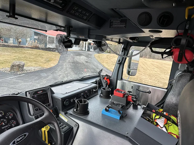 Cab interior dashboard view showing steering wheel, officer console, and mounted radios