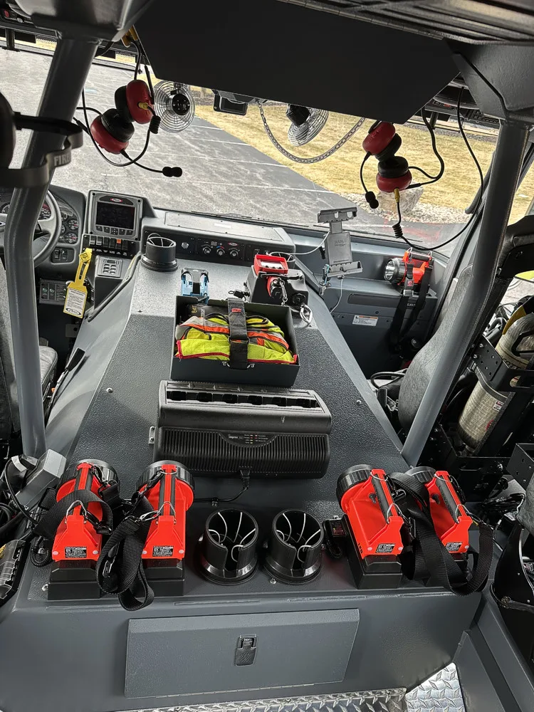 Cab interior rear view showing center console, portable lights, and crew seating