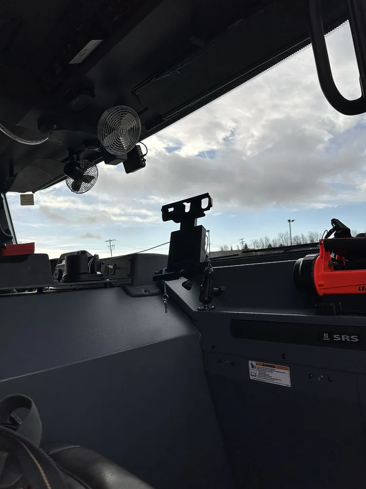 Cab interior side view showing dashboard shelf, cup holders, and passenger-side window