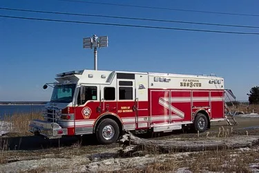 Driver-side profile view showing the rescue body compartments, cab doors, and wheel/tire area.