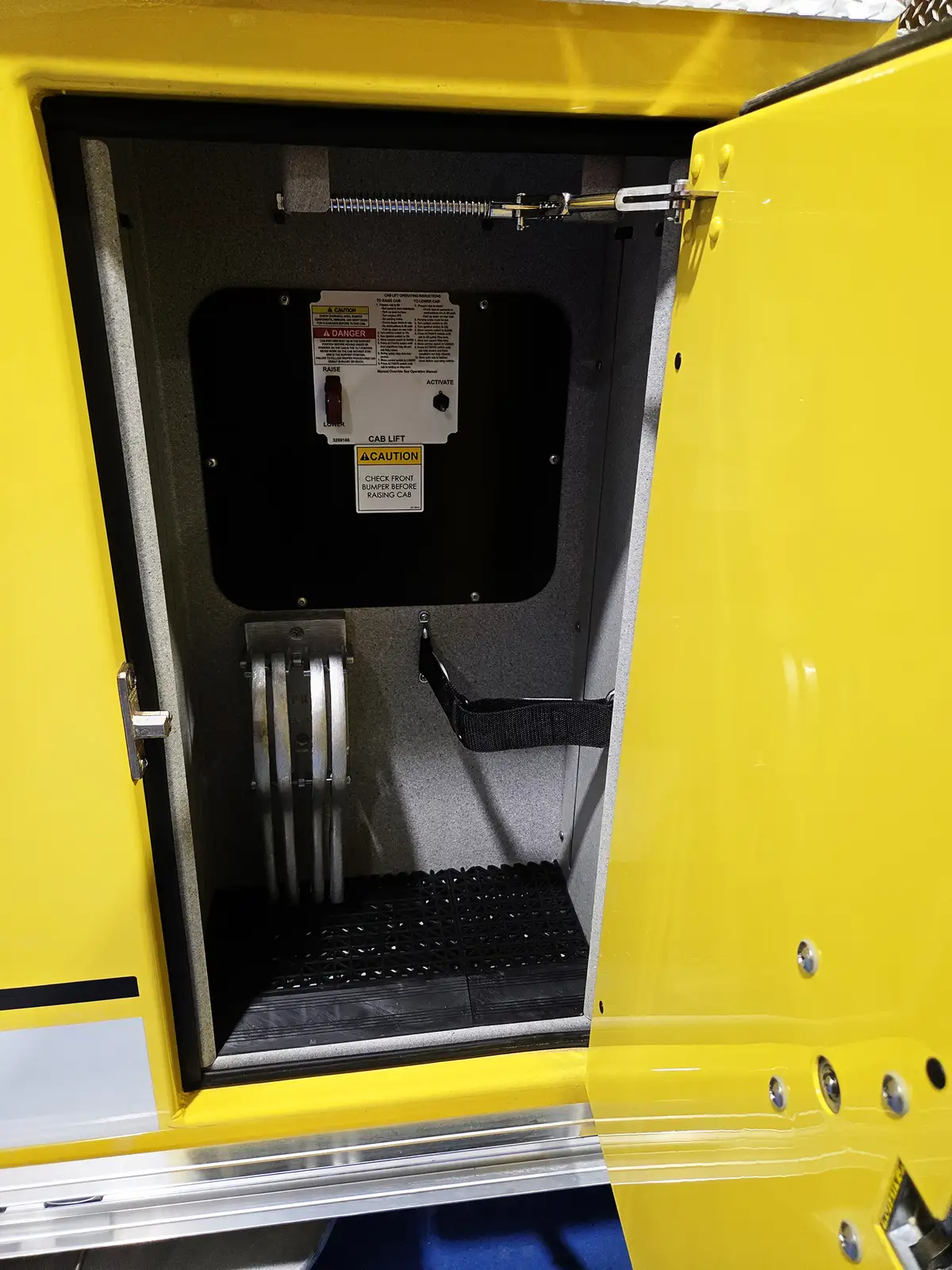 Open narrow side compartment showing hydraulic controls and coiled hose