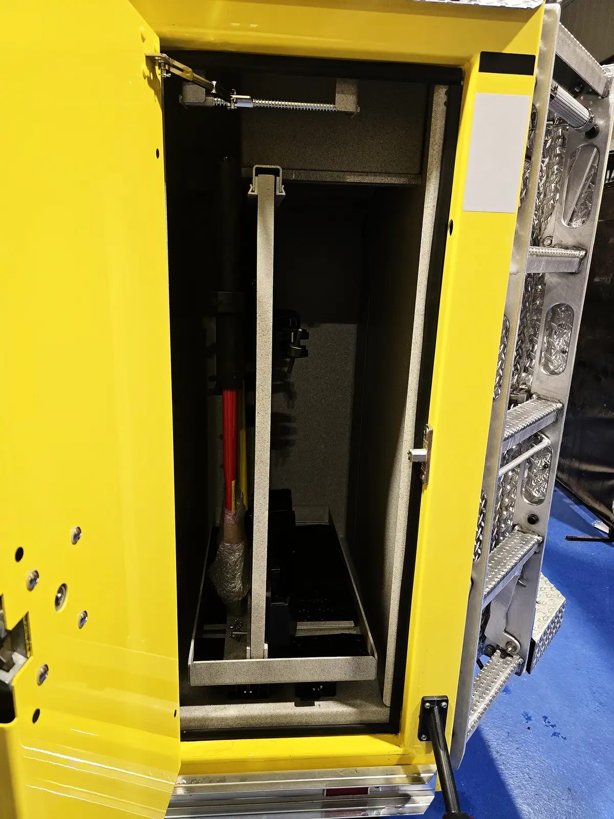 Open narrow vertical compartment showing long-tool storage channel