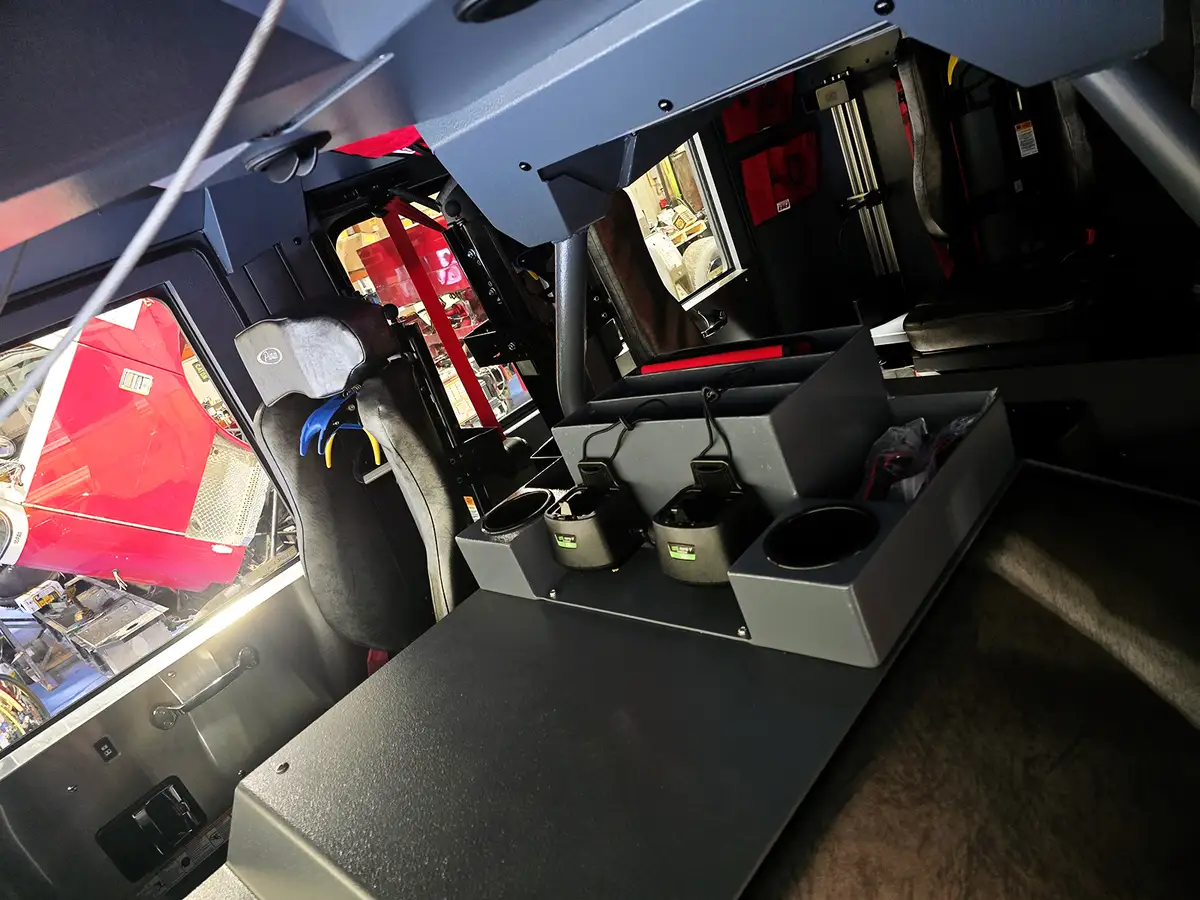 Cab interior view showing console controls, charging docks, and front seats