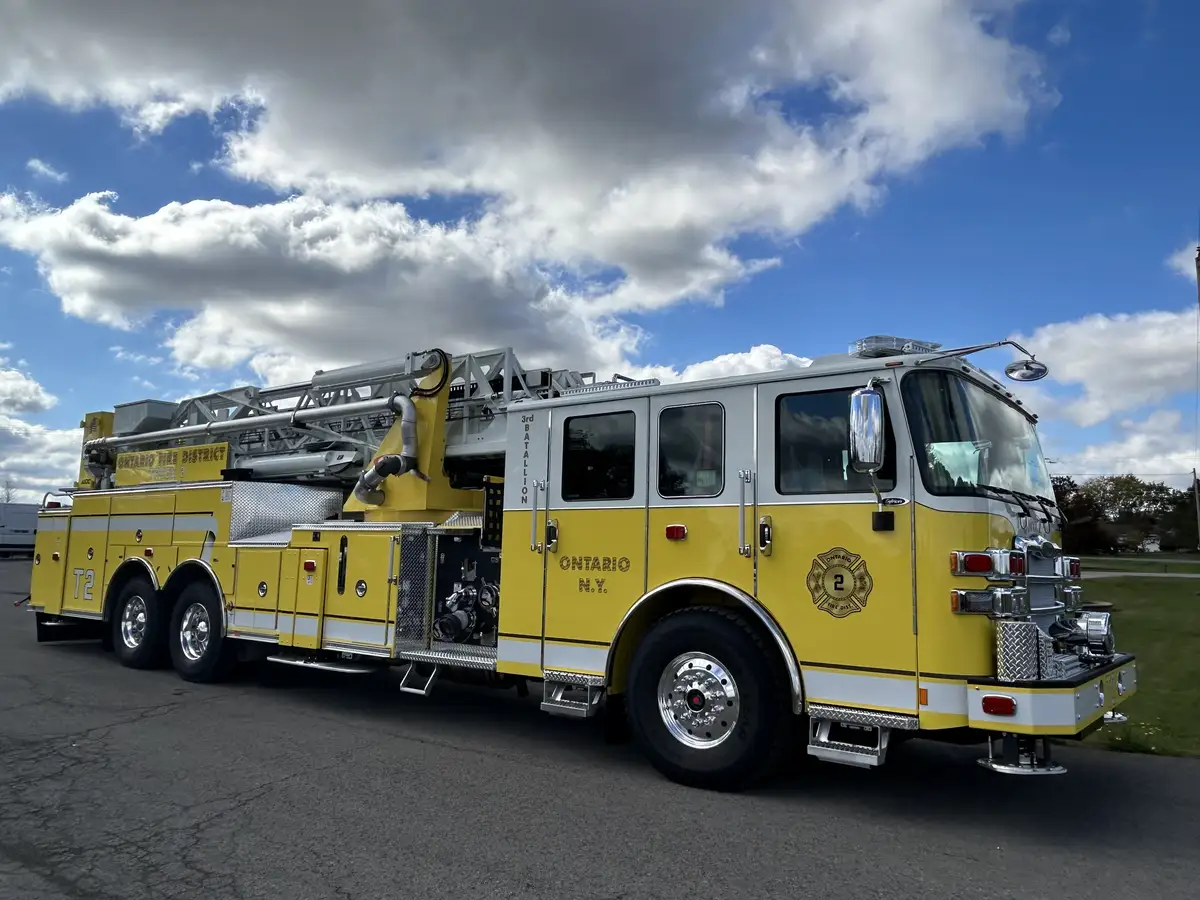 Officer-side full profile showing ladder sections, compartments, and tandem axles