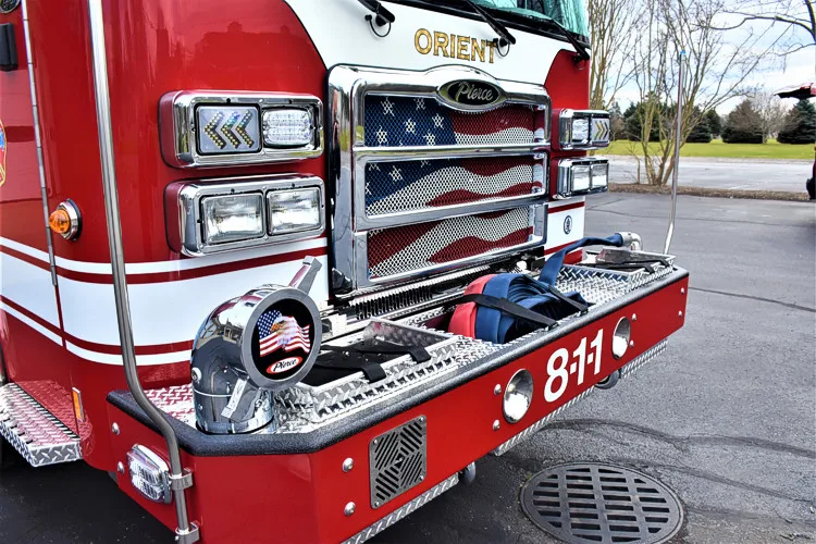 Front bumper corner close-up showing intake cap, siren, and grille detail
