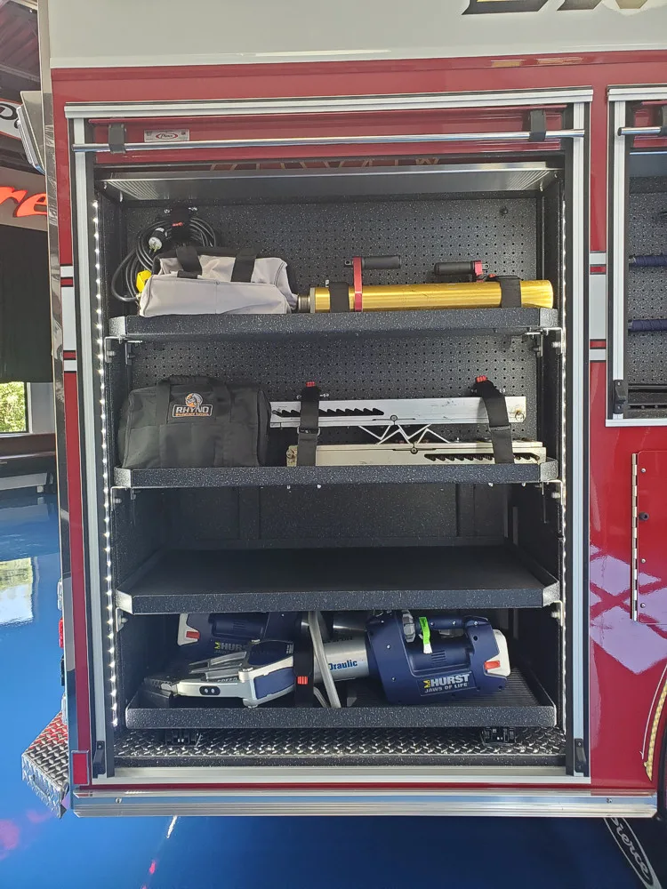 Open side compartment showing shelves with bags and utility equipment