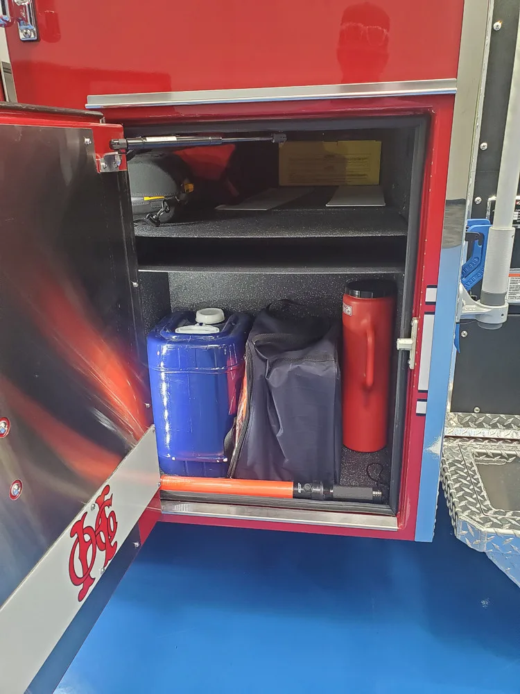 Open side compartment showing storage tubs and lower shelf bins