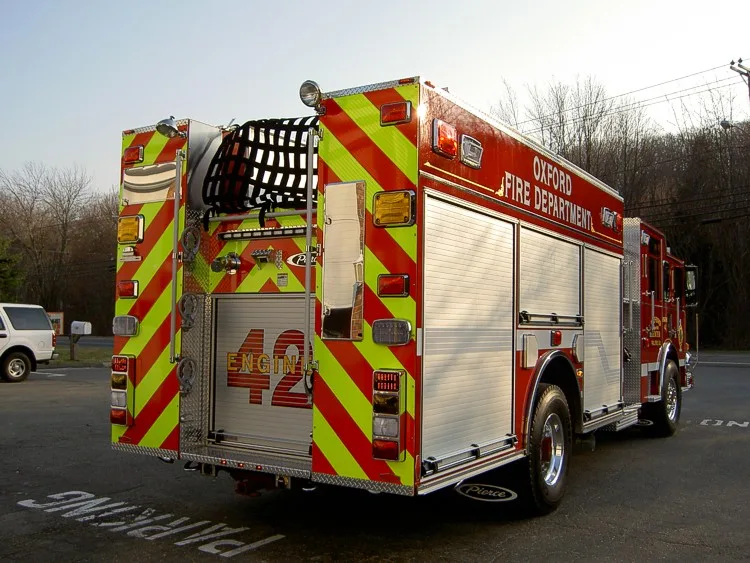 Rear-right exterior view showing chevrons, hosebed, and rear body panel