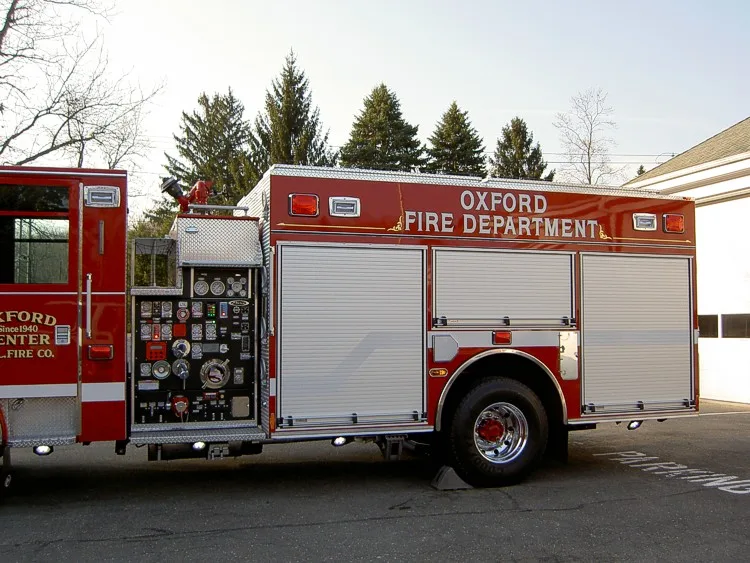 Driver-side rear view showing pump panel controls and rear wheel area