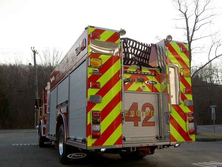 Rear-right view showing rear chevrons, hosebed rails, and side body
