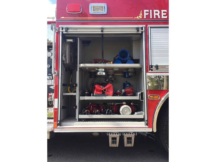 Open mid-body compartment showing hose fittings, valves, and adapters on shelves