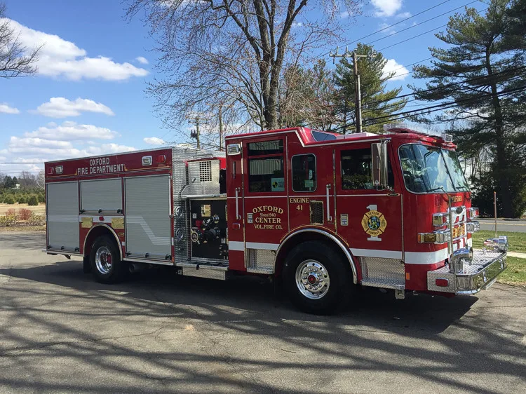 Passenger-side profile view showing pumper body, side compartments, and pump panel