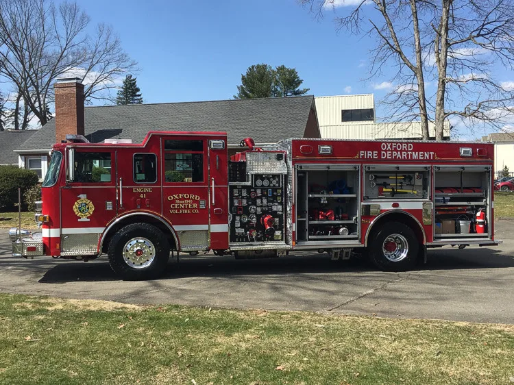 Driver-side profile view with open side compartments showing equipment shelves