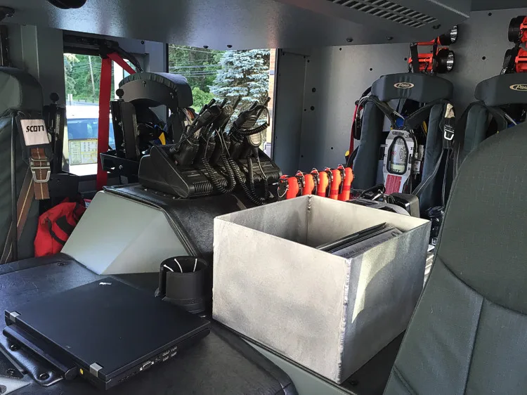 Cab interior rear seating view showing SCBA seats, radio chargers, and center console