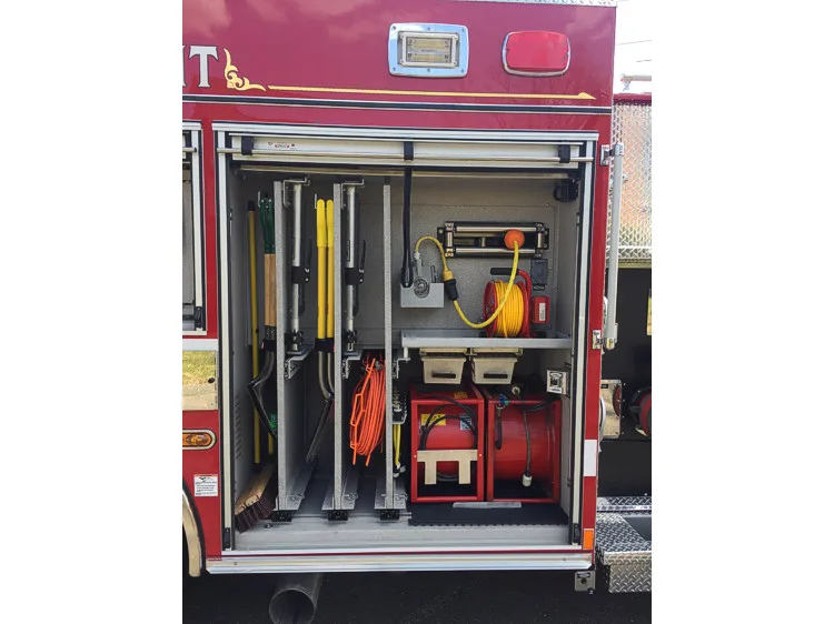 Open side compartment showing long-handled tools, cord reels, and a portable blower unit