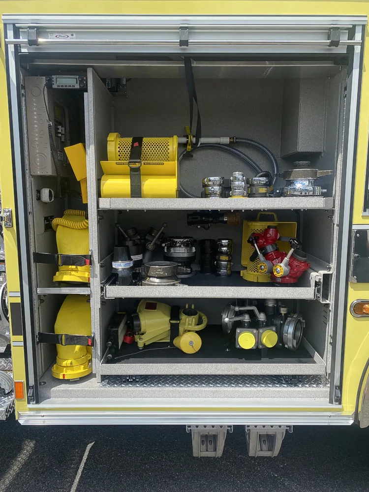 Open side compartment showing yellow equipment bags and shelf bins