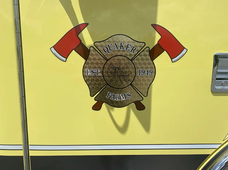 Cab door close-up showing crossed-axes style department crest