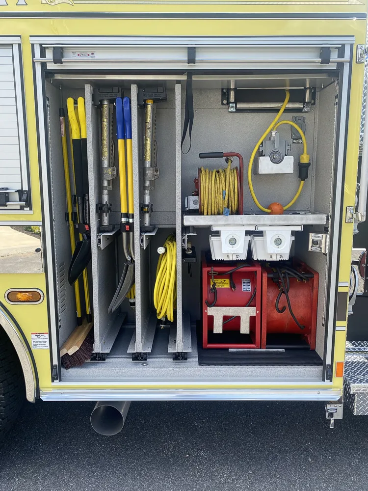 Open side compartment showing long tools and rescue bag storage