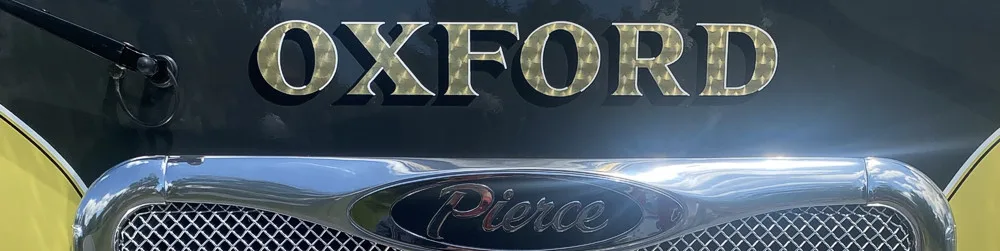 Front grille close-up strip showing Oxford script on chrome mesh