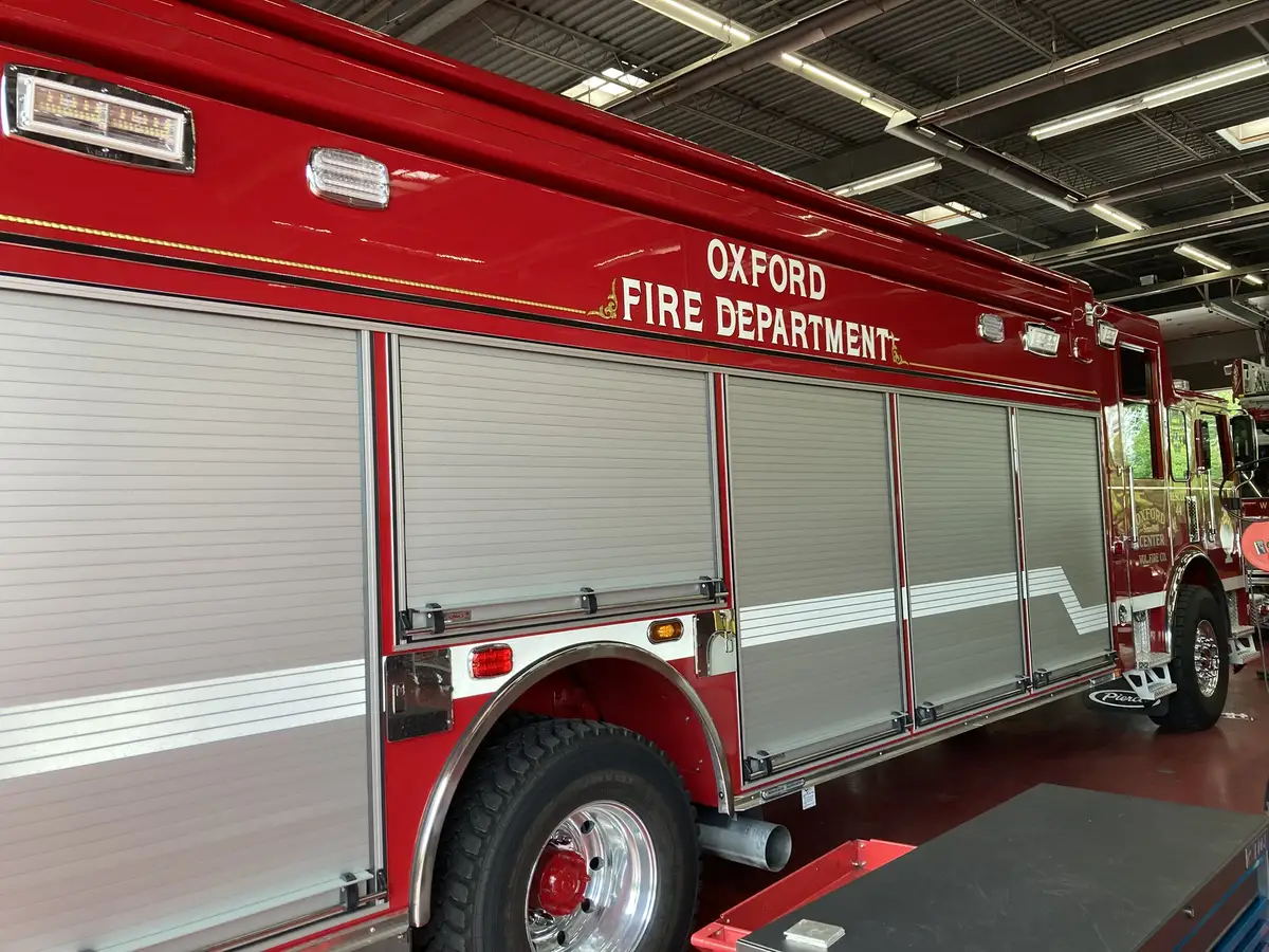 Driver-side profile view showing roll-up compartment doors and rear wheel area