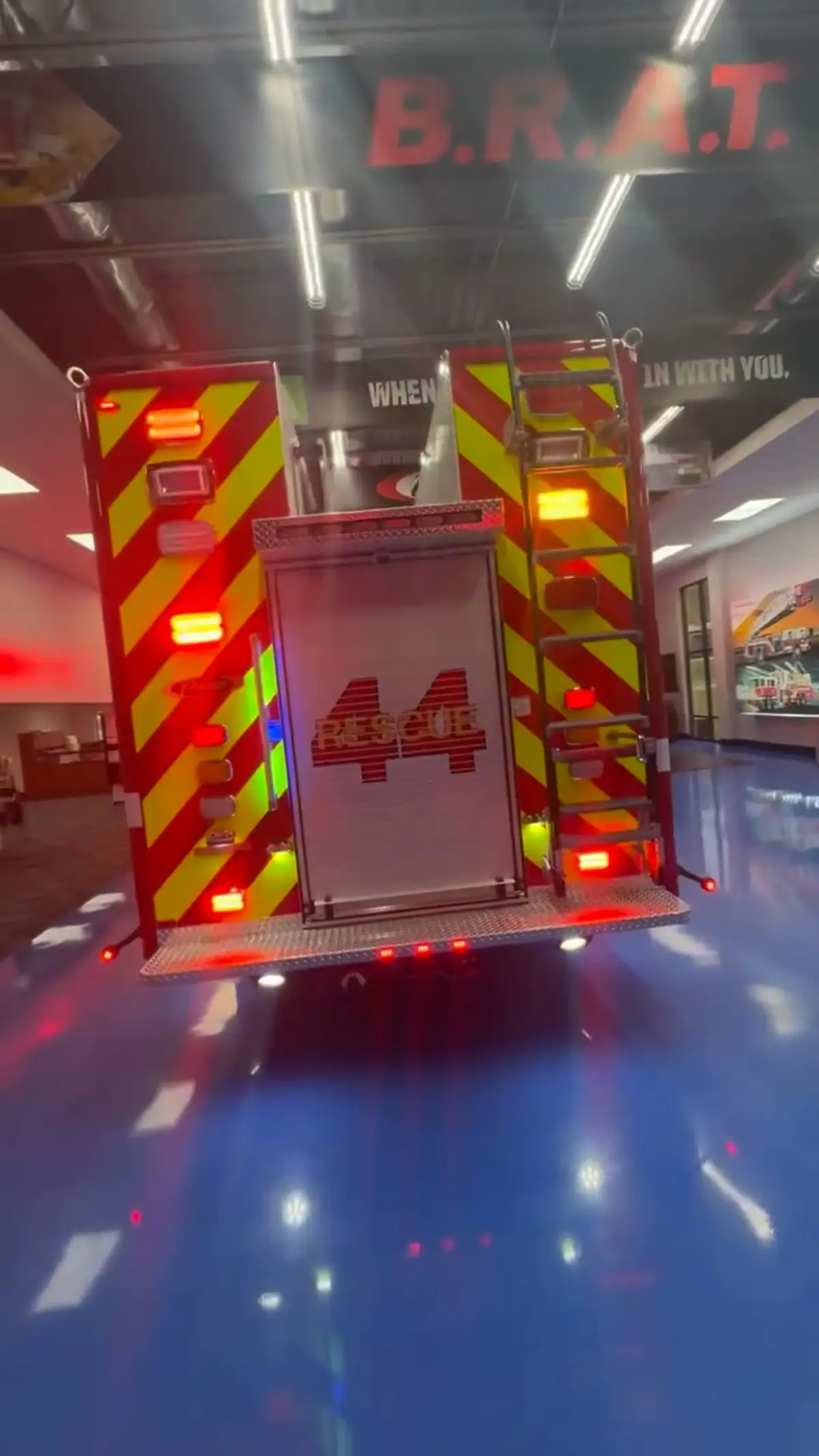 Rear view showing red-and-yellow chevrons, rear lights, and hosebed opening