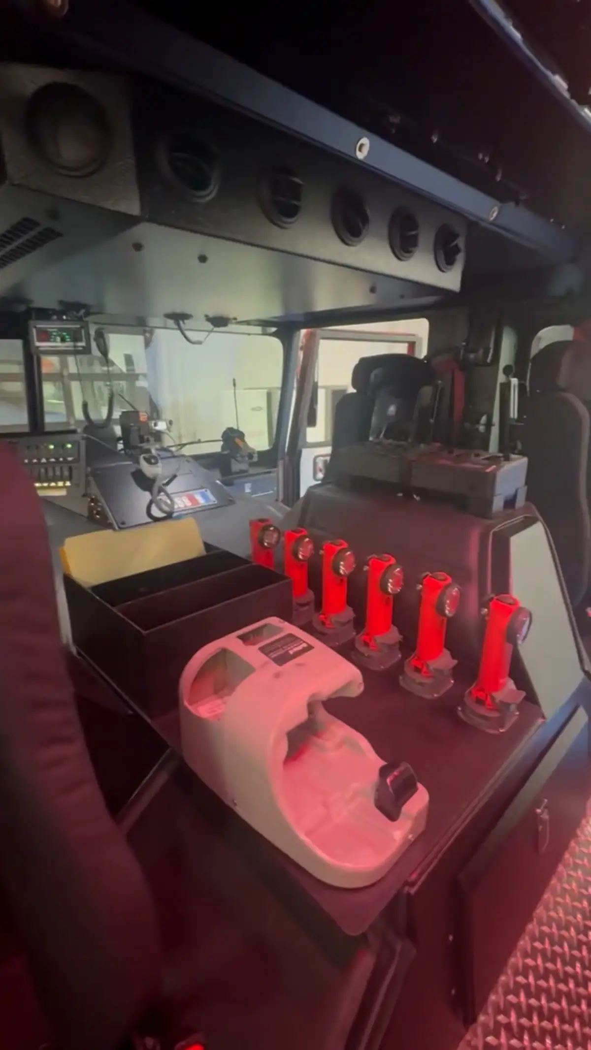 Cab interior console view with red lighting showing control panel and switches