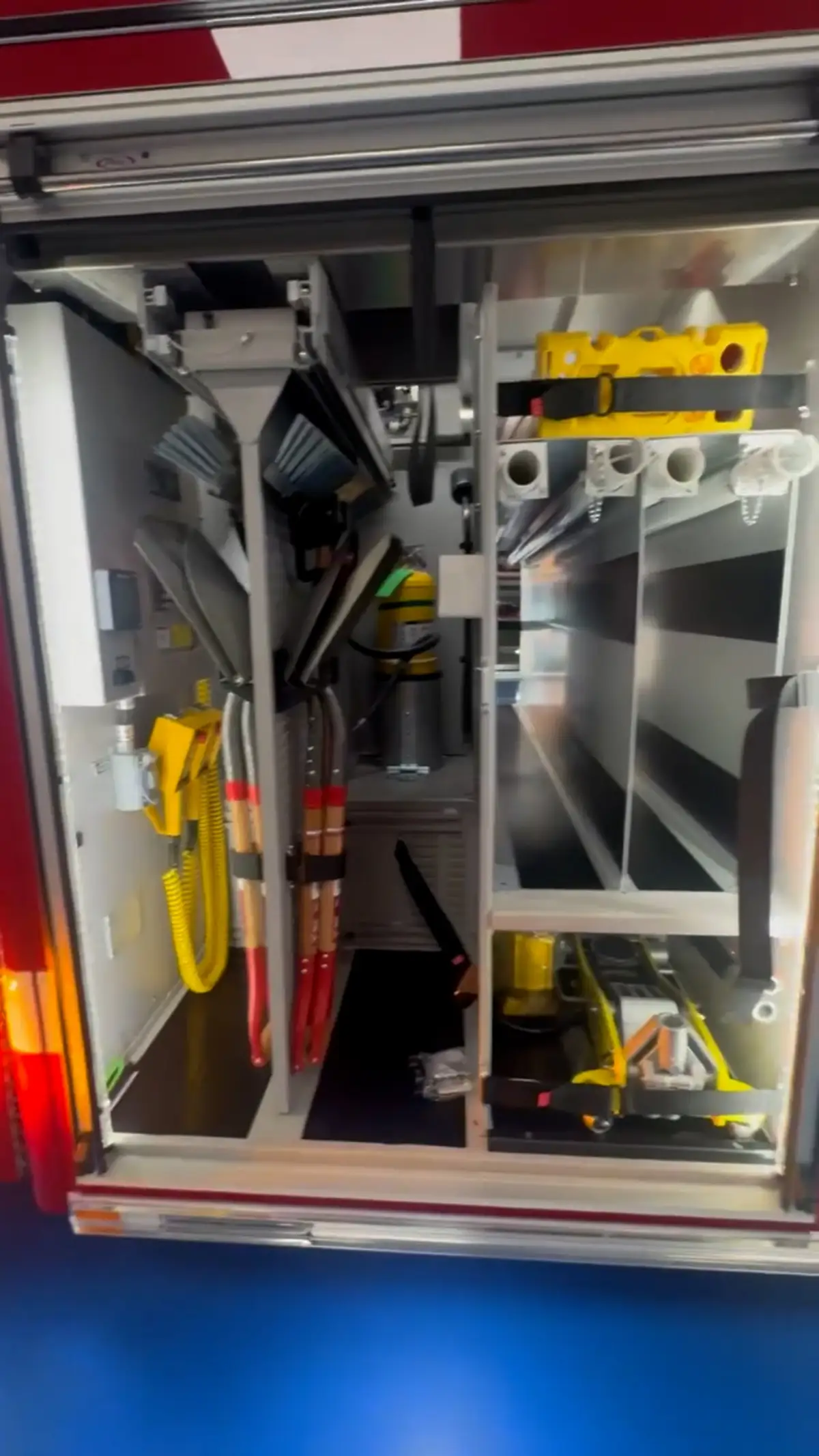 Open side compartment showing mounted tools and vertical equipment bays