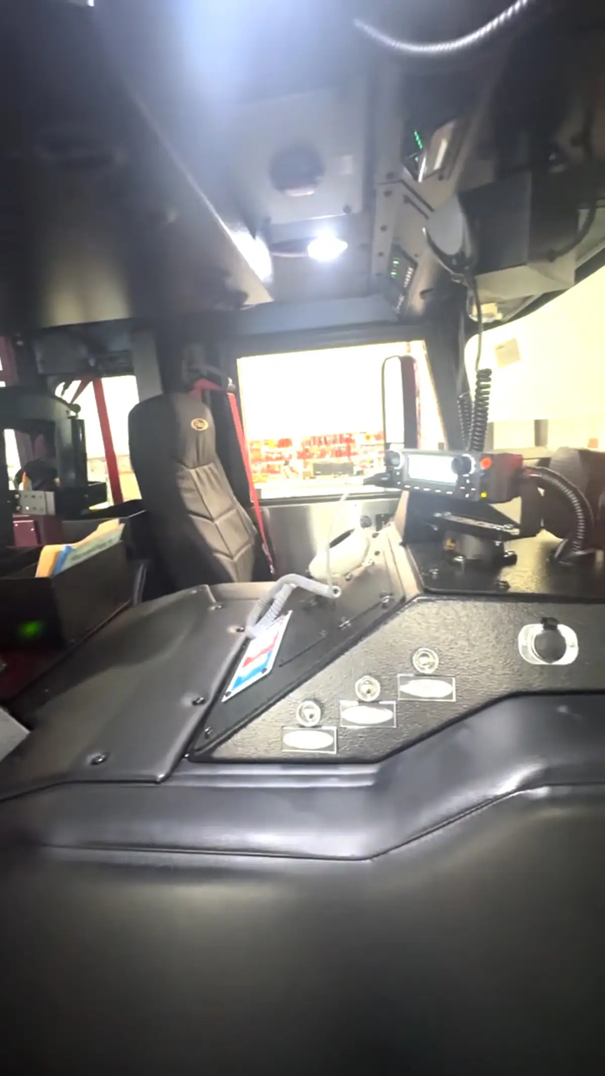 Driver cockpit view showing steering wheel, dashboard controls, and center console