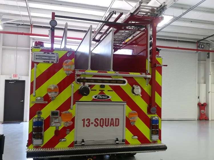 Straight rear view with red-yellow chevrons, rear fittings, and center rear roll-up door.