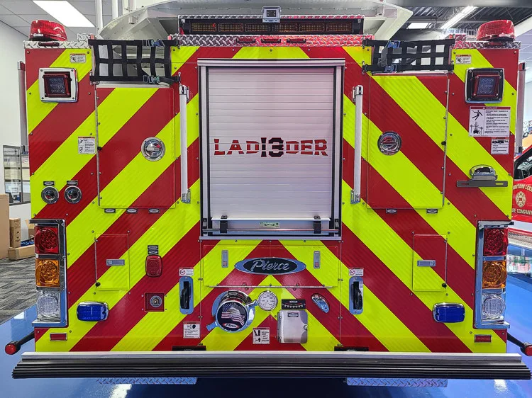 Rear view showing red-and-yellow chevrons and centered ladder label panel