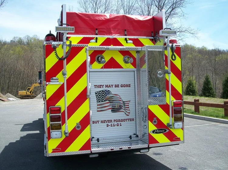 Straight rear view with red-yellow chevrons, rear roll-up door panel, and upper hosebed cover.