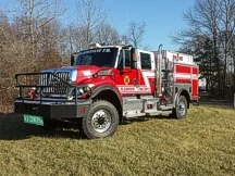 Front-left exterior view showing grille guard, cab, and side compartments