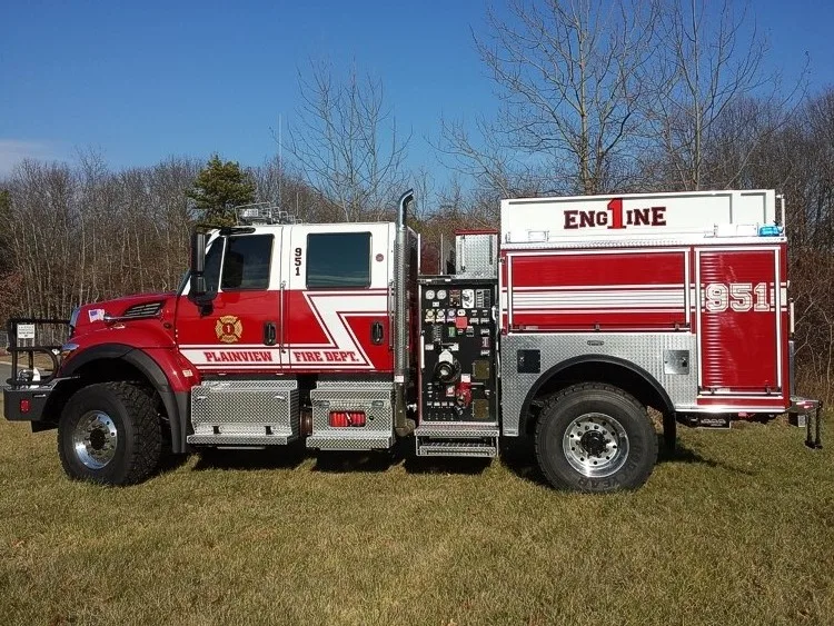 Rescue pumper driver-side profile showing pump panel, wheel area, and body compartments