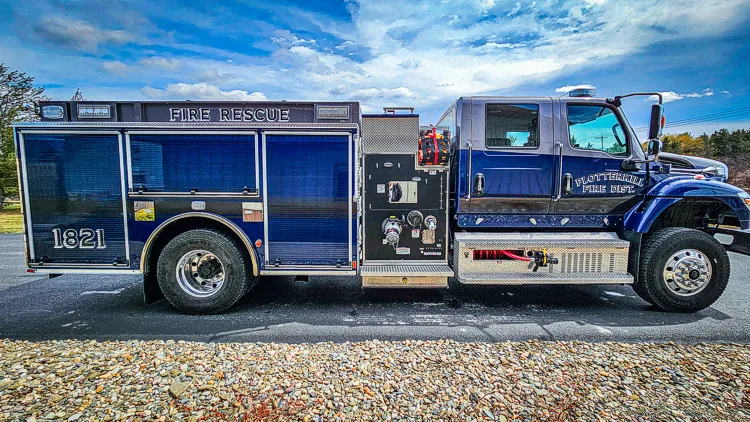 Driver-side profile with open compartments showing tools and storage bins