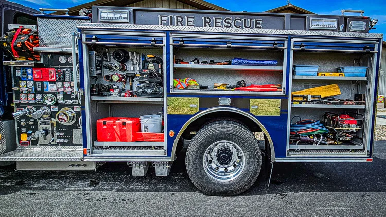 Driver-side profile with open compartments showing rescue tools and bins