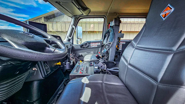 Cab interior front view showing center console, seats, and dashboard