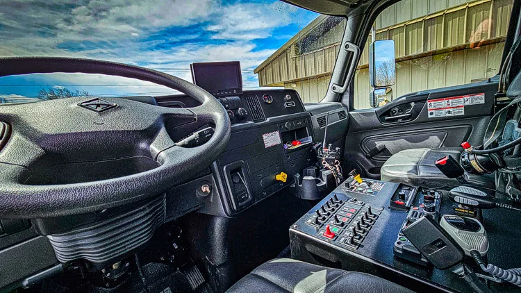 Driver cockpit view showing steering wheel, instrument cluster, and control panel