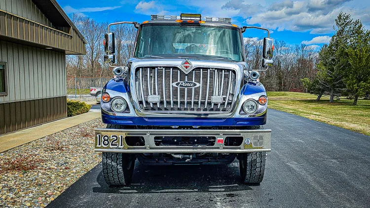 Head-on front view showing grille, bumper, and warning lights