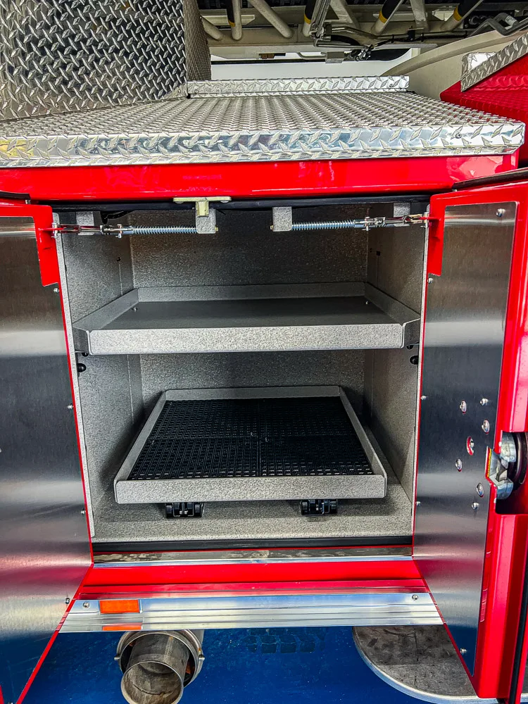 Open shallow side compartment showing an empty tray-style storage area