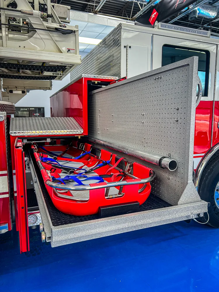 Open side compartment with tray pulled out showing hose and equipment bundles