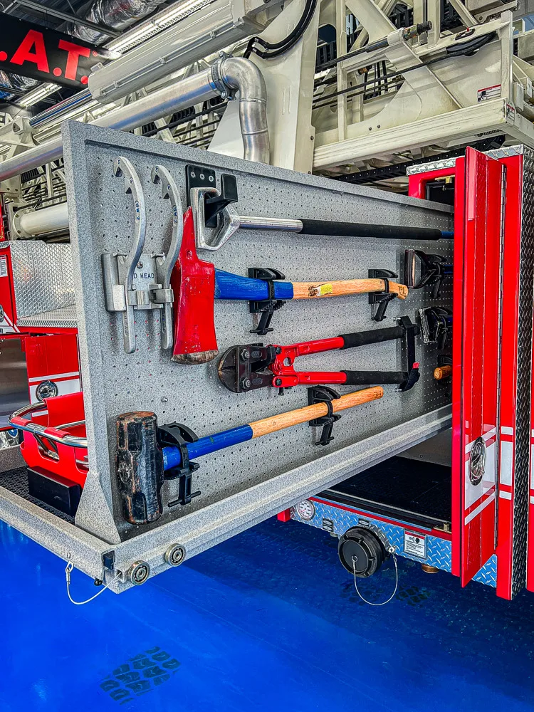 Open side compartment showing mounted nozzles, adapters, and hand tool storage